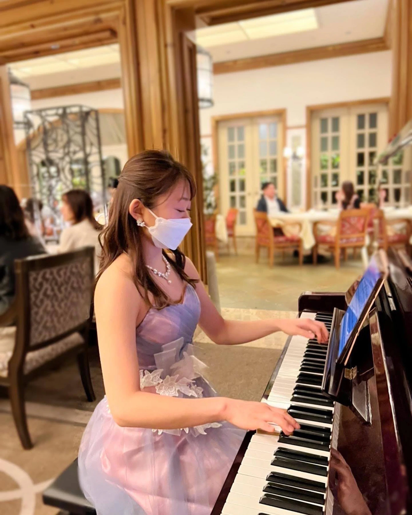 ドレス姿でピアノを弾く岡美咲さん