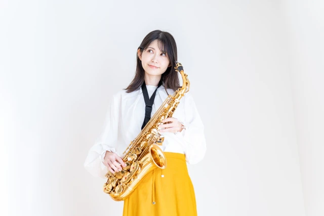 白い服を着たサックスを持つ女性
